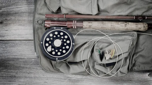 Старое снаряжение для ловли форели поверх рыболовного жилета — стоковое фото