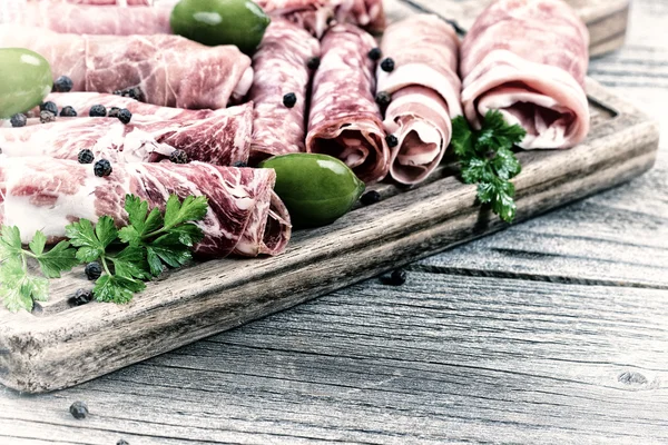Cold cut meats on serving board in vintage style — Stock Photo, Image