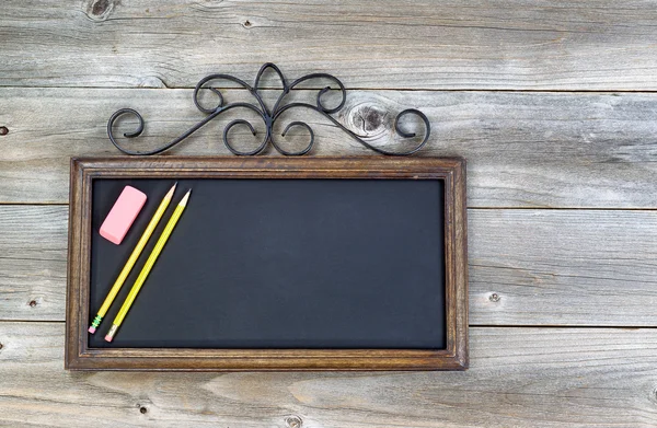 Alte Tafel mit Bleistiften und Radiergummi auf Holz — Stockfoto