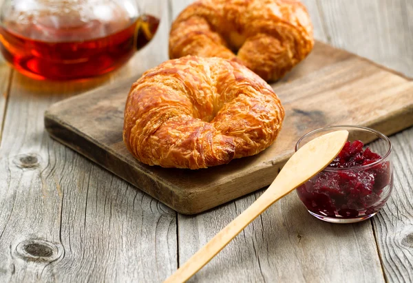 Čerstvé croissanty na serveru dřevěné desce připravené k jídlu — Stock fotografie