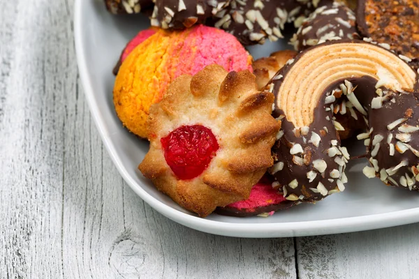 Galletas surtidas en plato blanco listas para comer —  Fotos de Stock