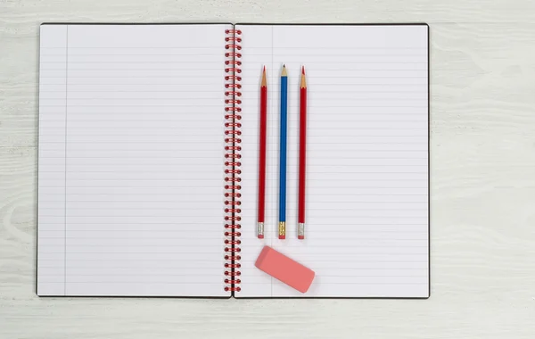 Blank notepad with pencils and eraser on desktop — Stock Photo, Image