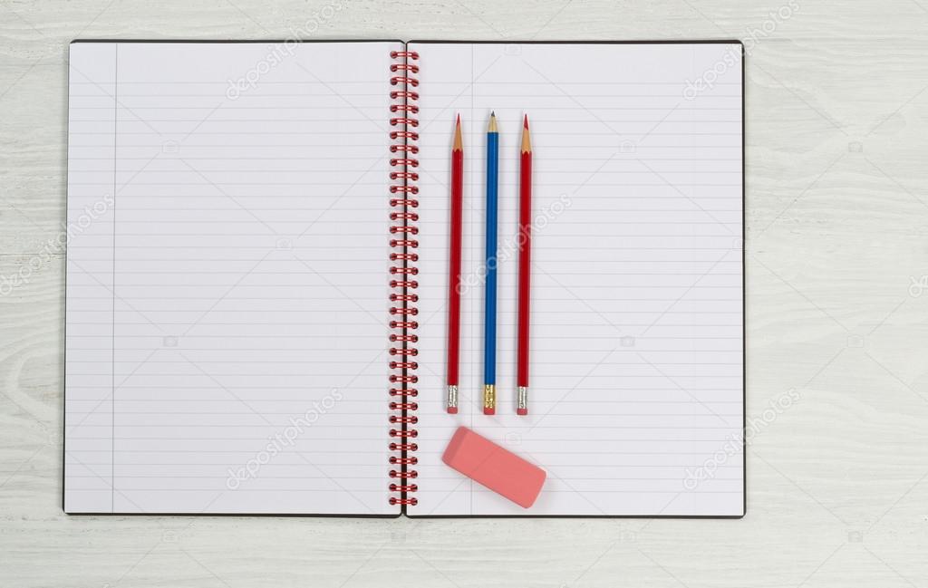 Blank notepad with pencils and eraser on desktop 