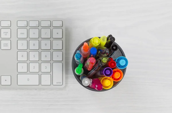 Pens and markers in container on top of desk — Stock Photo, Image