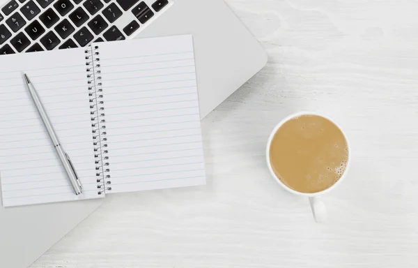 Laptop computer with coffee and blank notepad on white desktop — Stock Photo, Image