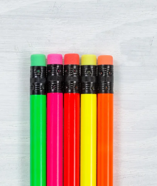 Colorful pencil tip erasers on wooden white desktop — Stock Photo, Image