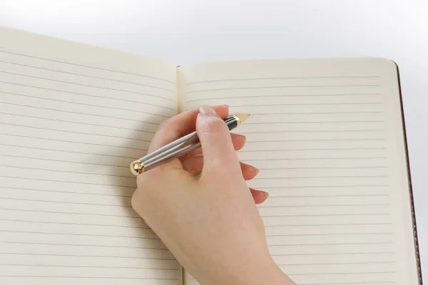 Female hand ready to write with pen and paper — Stock Photo, Image