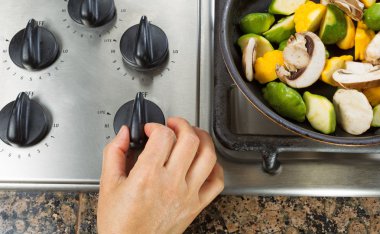 Turning on natural gas stove to cook vegetables  clipart