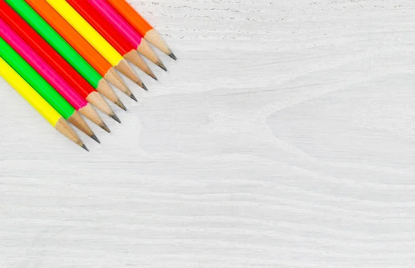 Bright colorful pencil tips on white wood desktop — Stock Photo, Image