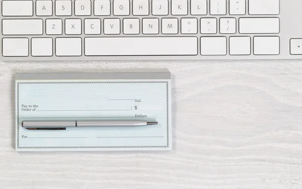 Chequera en blanco con bolígrafo en escritorio blanco — Foto de Stock