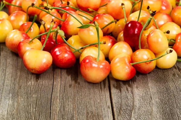 Cerises Rainier mûres sur table boisée âgée — Photo