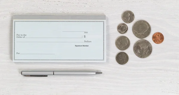 空白支票簿与笔和白色桌面上的硬币 — 图库照片
