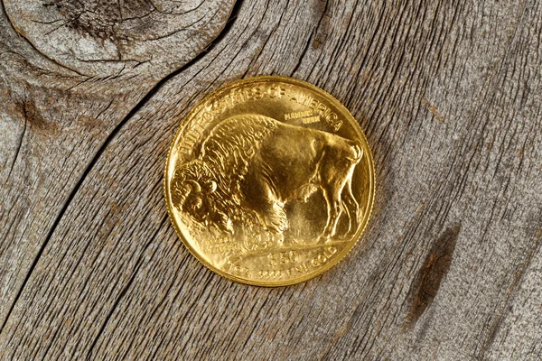 Fine gold Buffalo Coin on rustic wooden background — Stock Photo, Image