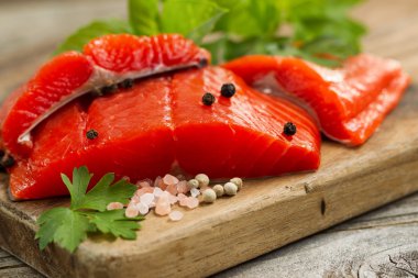 Fresh Copper River Salmon fillets on rustic wooden server with s