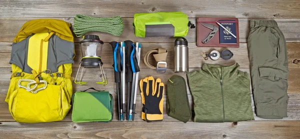 Hiking and camping gear organized on rustic wooden boards — Zdjęcie stockowe