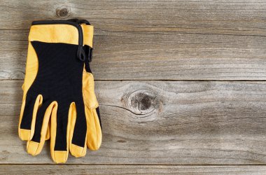 New leather and nylon work gloves on rustic wooden boards 
