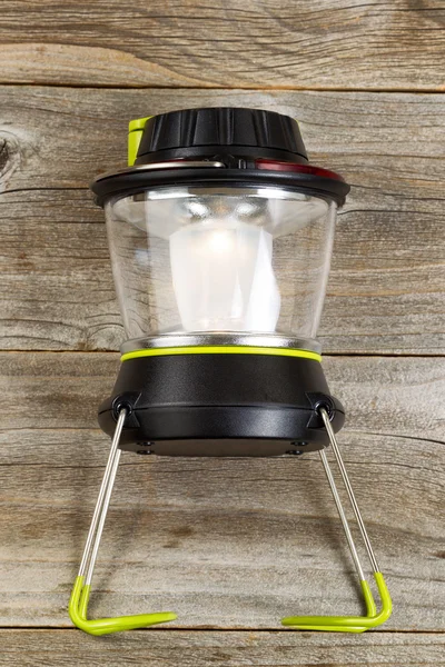 New outdoor battery lantern on rustic wooden boards — Stok fotoğraf