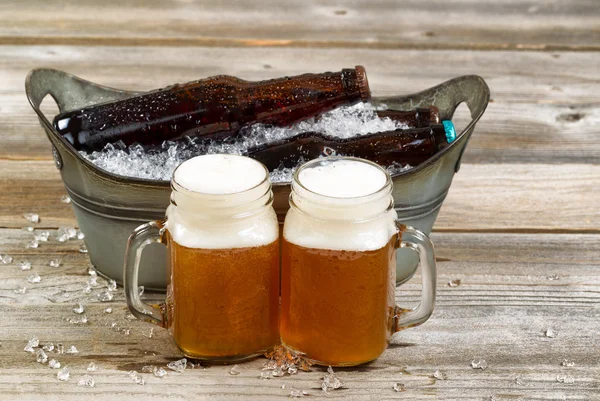 Two pints of fresh cold beer in front of bucket filled with ice — Stock Photo, Image