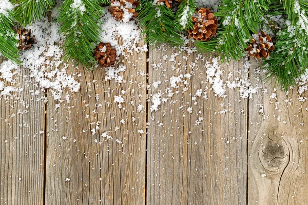 Noel kenarlığı süsleri ile kar rustik ahşap kurullarında — Stok fotoğraf