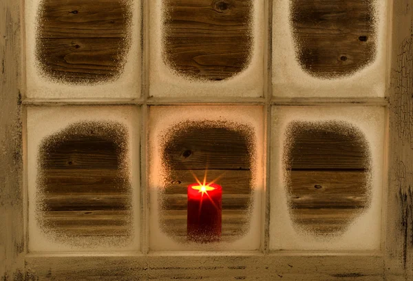 Λαμπερό κόκκινο κερί σε χιόνι κάλυψε παράθυρο — Φωτογραφία Αρχείου