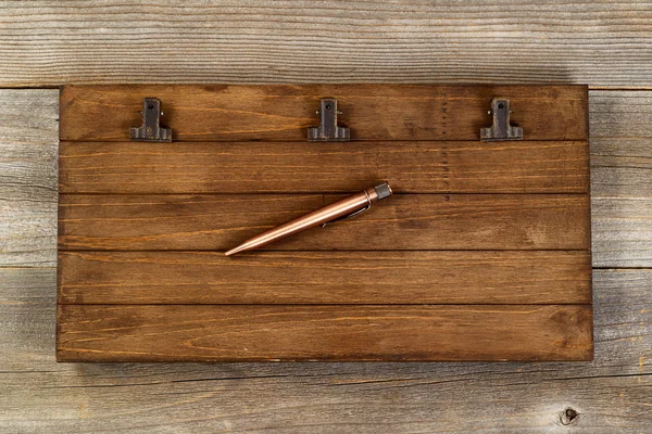 Clipboard vintage e caneta de metal na área de trabalho de madeira velha — Fotografia de Stock