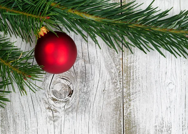 Grand fir branch with singe red ornament on rustic white wooden — Stock Photo, Image