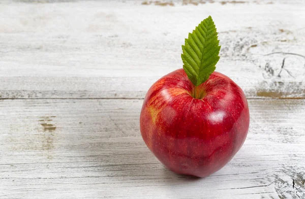 Färska hela rött äpple på rustika vita träskivor — Stockfoto