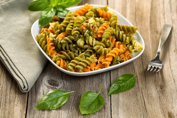 Pesto casero con pasta sobre mesa de madera rústica —  Fotos de Stock