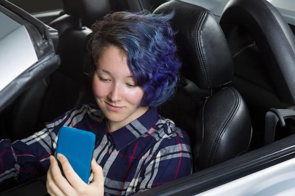 Ragazza adolescente driver sorridente mentre guarda il testo sulla cella — Foto Stock