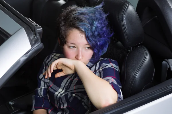 Depressed teenage girl sitting in driver side seat of car — Stock Photo, Image