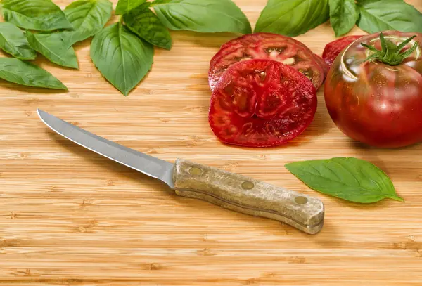 Ahşap kesme tahtası üzerinde ev yapımı organik domates dilimleri — Stok fotoğraf
