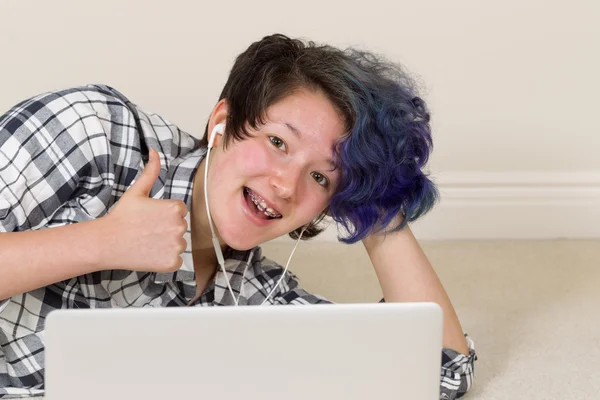 Adolescente menina dando polegares para cima enquanto em casa no computador — Fotografia de Stock