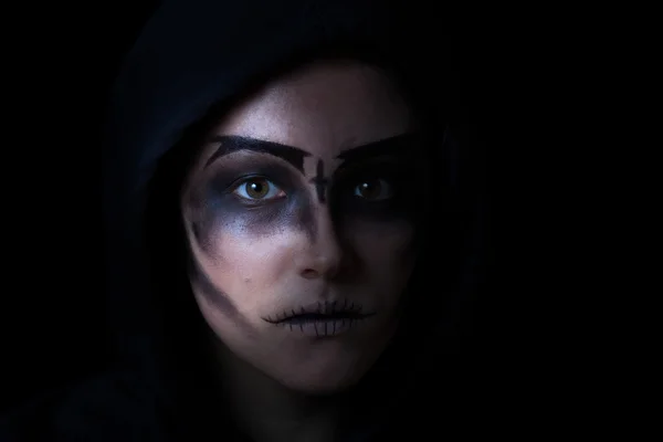 Chica en sudadera con capucha con maquillaje de la cara de miedo sobre fondo negro —  Fotos de Stock