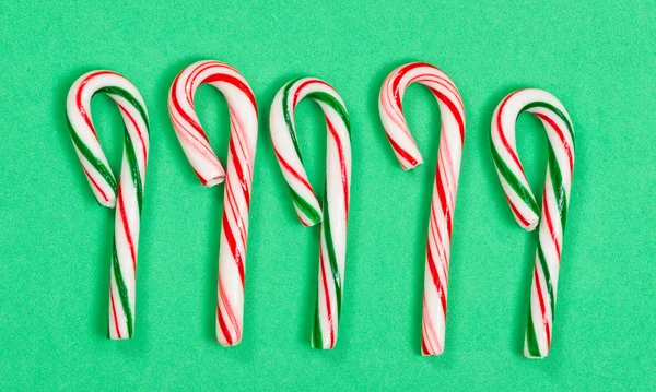 Collection of colorful candy canes on green background — Stok fotoğraf