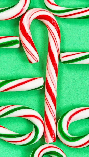 Candy canes joined in a collection on a green background — Stock Photo, Image