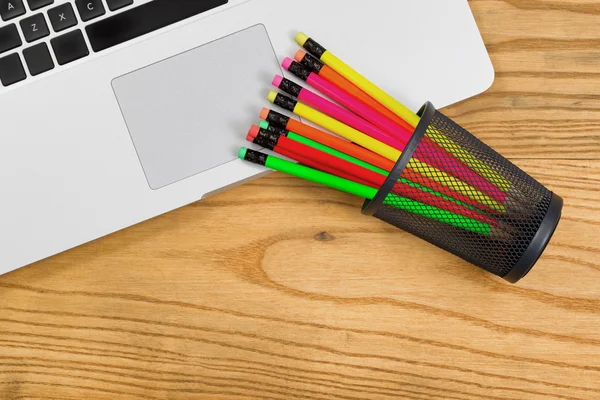 Desktop with colorful pencils on top of computer — Stock Photo, Image