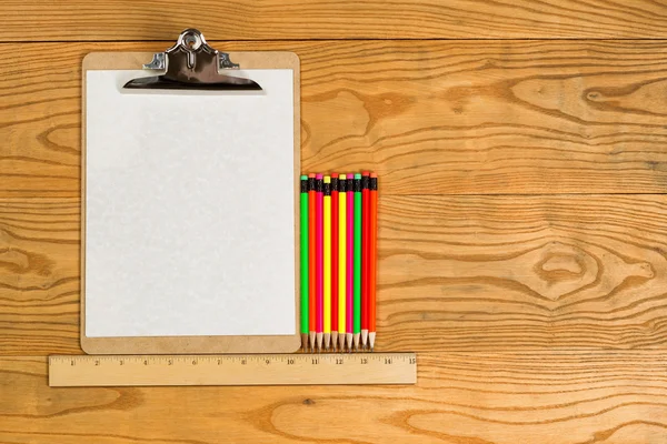 Portapapeles en blanco con papel y lápices de colores en el escritorio —  Fotos de Stock