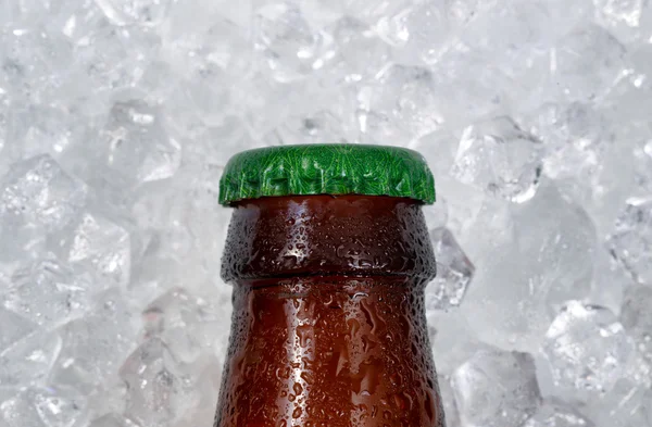 Single beer bottle cap cooling down on pile of ice — Stock Photo, Image