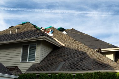 Home roof being replaced with new composite roofing materials clipart