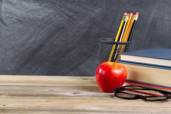 Old wooden desktop with reading materials and blackboard — Stock Photo, Image