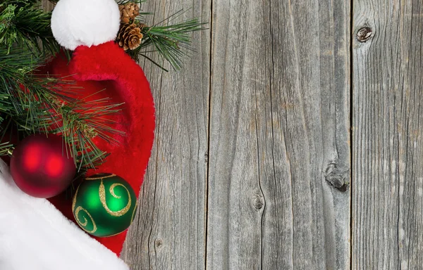 Tappo Babbo Natale con ornamenti e ramo sempreverde su tavole di legno — Foto Stock