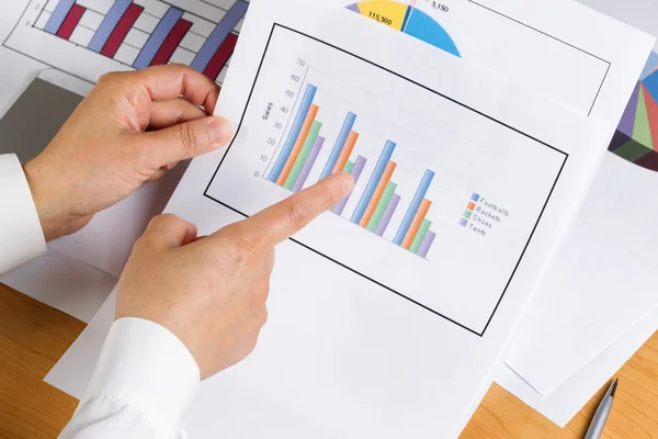 Gráfico de gráfico de barras de mano mientras mira los datos financieros — Foto de Stock