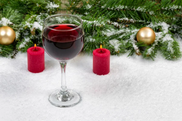 Vino tinto con objetos navideños cubiertos de nieve fresca — Foto de Stock