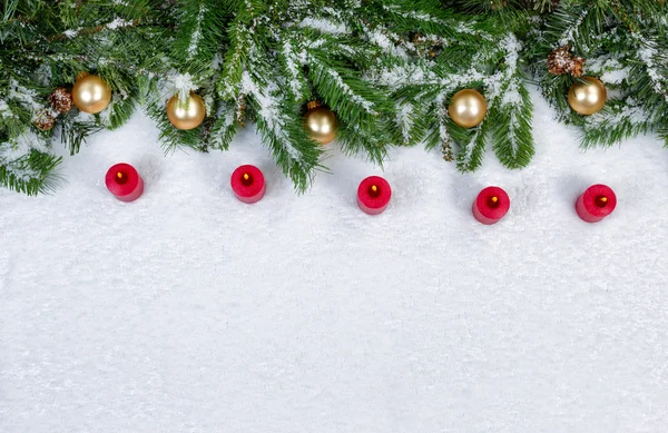 Red burning candles and Christmas objects covered with fresh sno — Stock Photo, Image