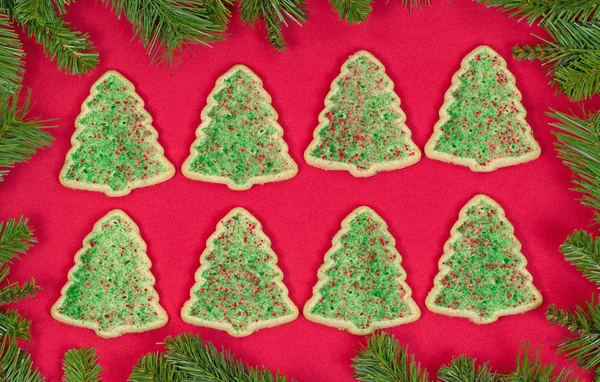 Biscotti a forma di albero di Natale circondati da bordo sempreverde su — Foto Stock