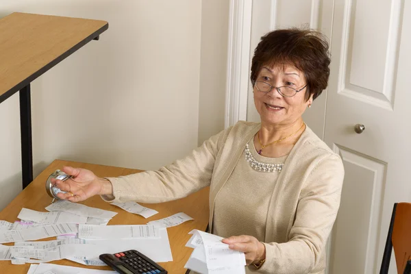 Oudere vrouw gefrustreerd met haar financiële rekeningen — Stockfoto