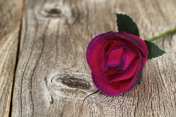 Close up of single wooden red rose on aged wood — Stock Photo, Image