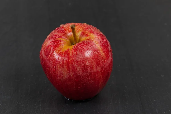 Verse rode hele appel op zwarte leisteen stenen achtergrond — Stockfoto