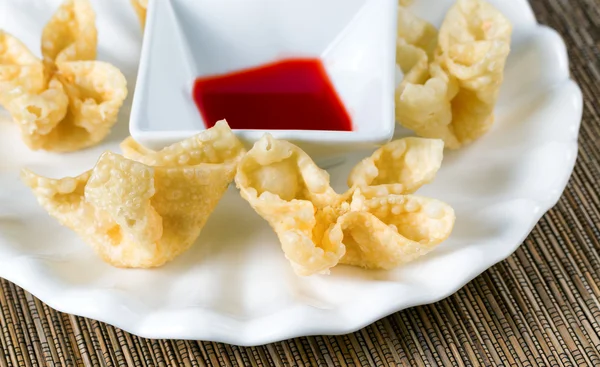 Crispy fried wanton and sauce in white bowl on bamboo mat — Stock Photo, Image