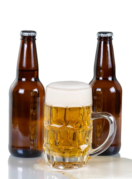 Beer flowing out of glass mug onto glass surface — Stock Photo, Image